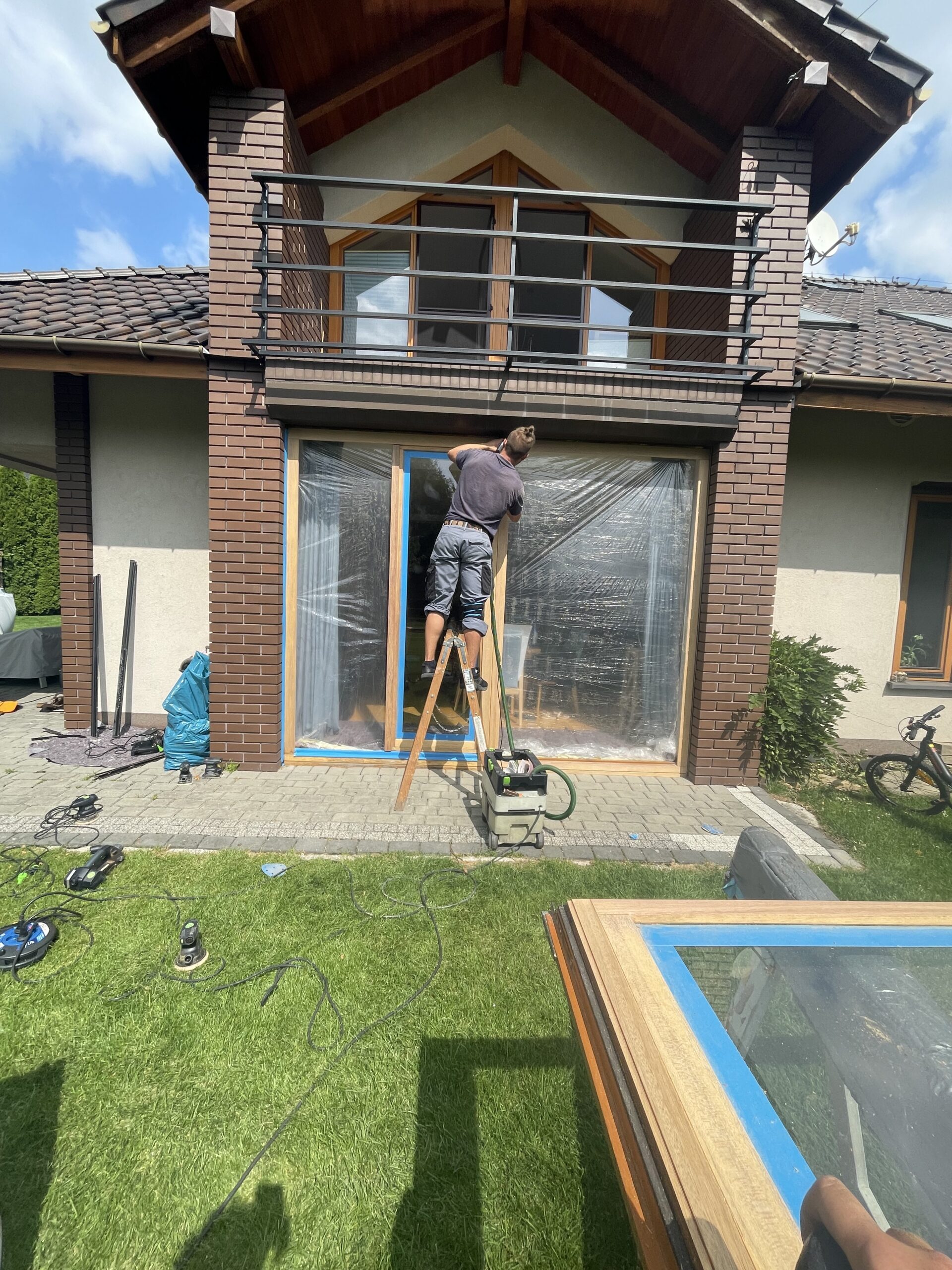 Fachowiec Fenster Service montuje drewniane drzwi tarasowe podczas realizacji